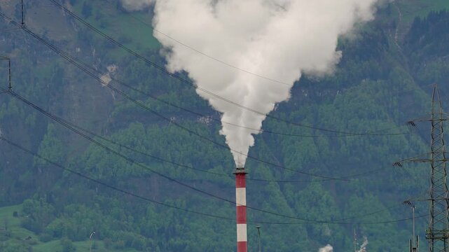 Industrial Smoke Rising from Factory Chimney, Thick White Emissions Released Into the Sky, Industrial Plant Pollution and Atmospheric Exhaust from Manufacturing Facility