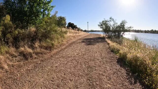 Dirt path alongside the Proserpina Roman Dam under a clear blue sky next to Merida, province of Badajoz, Extremadura, Spain