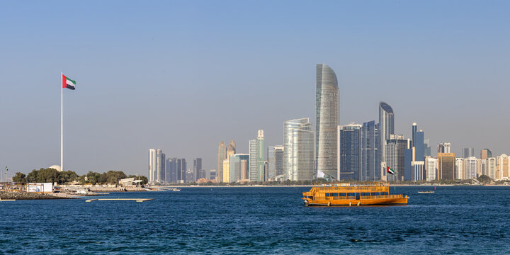 Abu Dhabi skyline with skyscrapers and Dhow boat at sea panorama in Abu Dhabi, United Arab Emirates