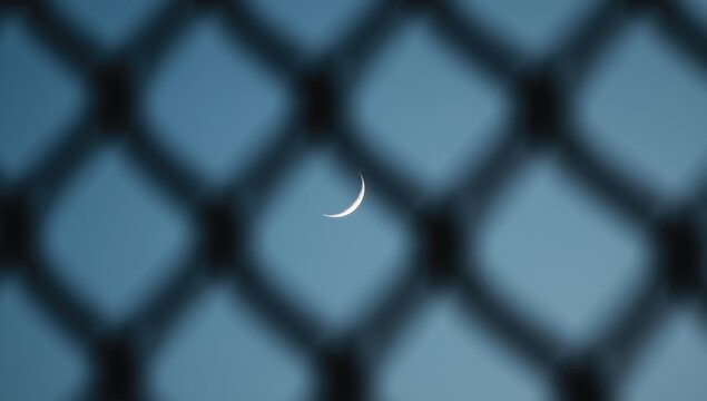 Pale blue textured background with a sliver of crescent moon