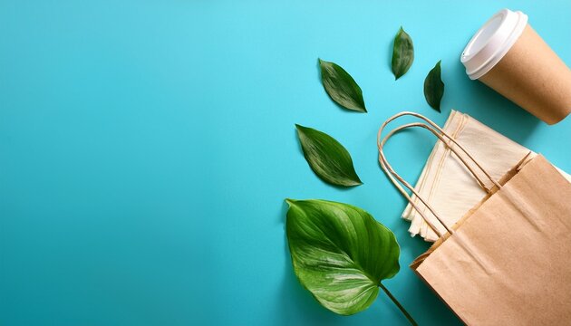 eco friendly takeaway packaging with paper bag reusable cups napkin and green leaves on blue background