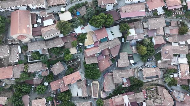 4K aerial video of Şirince village near Izmir, Turkey, showcasing its traditional houses, lush hills, narrow streets, and picturesque Mediterranean landscape.