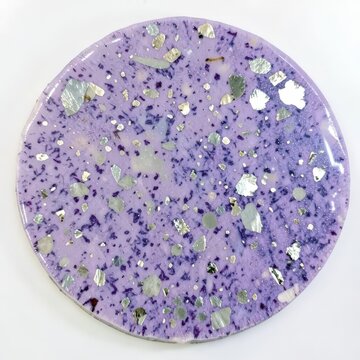 Glossy lepidolite mica slab with silvery flecks, flat round lavender purple mineral on white surface