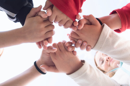 Children hold hands; the concept of friendship, unity, teamwork, and support.