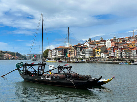 A Portuguese barco rabelo carrying barrels of port wine on the Douro River. Porto. Portugal.