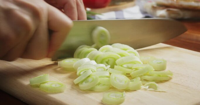 Freshly cut leek is prepared as an ingredient for homemade soups, stir fry dishes, noodles, and other healthy recipes.