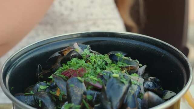 Close-up of a pot of mussels topped with parsley and red onion, Cote d'Azur, France