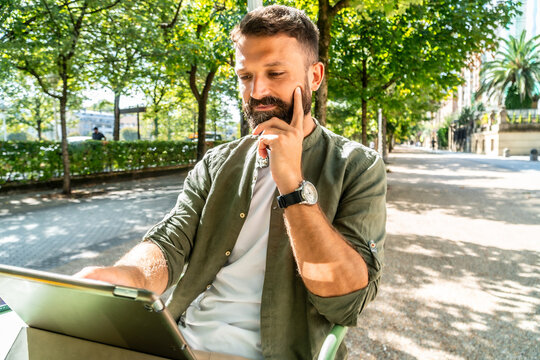 Man thinking while working on tablet in park