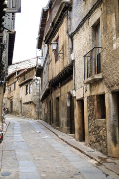 Narrow street with Typical houses with granite stone plinths and upper floors with geometric wooden frameworks in La Alberca town