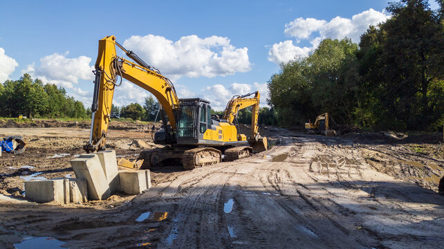 xcavator digs trenches at a construction site. Concept for laying external sewer pipes.