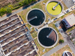Wastewater treatment plant showing large circular tanks and filtration systems in operation during...