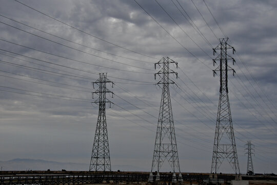 Three intrastate electrical pylons against cloudy skies 