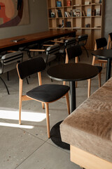 Modern cafe interior with wooden chairs and tables bathed in sunlight © shine.graphics