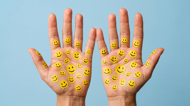 Open Human Palms with Yellow Smiley Face Stickers on Blue Background