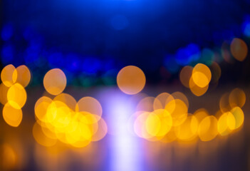 Obraz premium Golden bokeh lights with blue defocused background and central violet glow for festive night abstract background and design