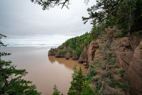 Iconic red sandstone cliffs and sea caves of Hopewell Rocks Provincial Park in the Bay of Fundy, New Brunswick.