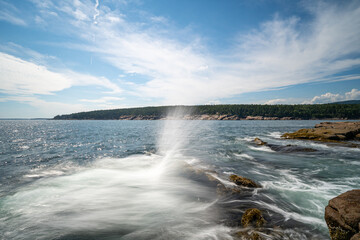 Fototapeta premium Ocean water spraying upward off granite rocks along the rocky coast at Otter Point in Acadia National Park on Mount Desert Island, Maine.