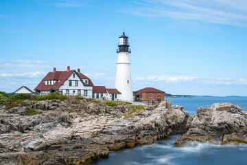Portland Head Light standing atop rugged rocky cliffs along Casco Bay in Cape Elizabeth, Maine, Long Exposure photo. © Eli