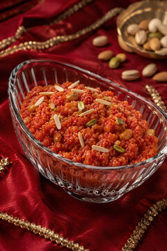 Traditional Gajar Halwa With Almond Slivers on Festive Red Fabric