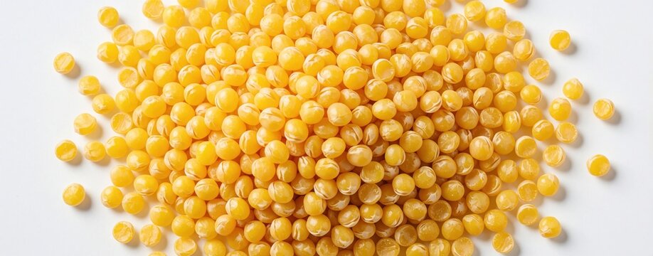Bright yellow split peas form a textured pile on a clean white surface. These legumes offer a vibrant, natural food ingredient for healthy meals and recipes.