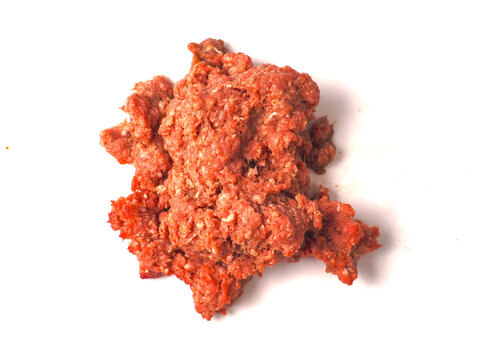 Raw ground beef in a white ceramic bowl. Meat appears freshly minced with visible fat. Bowl has slight residue from preparation. Shot on clean white background. High detail showing texture