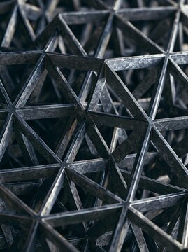 Close-up of a geometric pattern made up of multiple interlocking triangles. the triangles are arranged in a repeating pattern, creating a sense of depth and dimension.