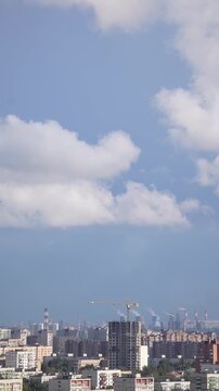 Timelapse of urban construction progress with buildings, cranes and moving clouds above the city skyline, showing city growth and modern development