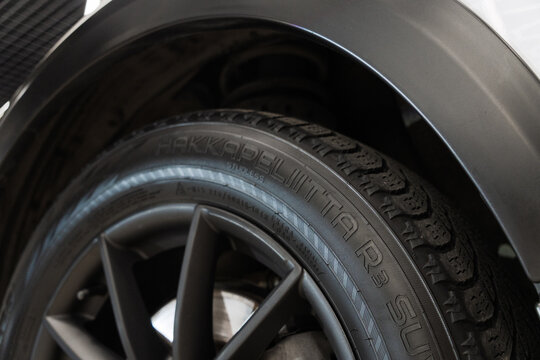 Black rubber sidewall of premium winter friction tire from famous Finnish manufacturer Nokian Tyres Hakkapeliitta R3 SUV close up, vehicle wheel part with texture near car arch background outdoor.
