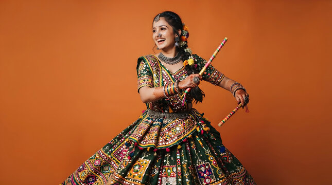 Indian Woman Twirling with Dandiya Sticks in Traditional Green Mirror Work Ghagra Dress