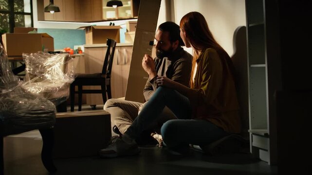 Homeowners arguing during moving day in a new residence, experiencing stress, disagreement and anxiety as the couple faces the emotional challenges of relocation among moving boxes and belongings.