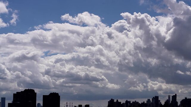 Stunning stock video of dramatic moving clouds rolling over a sprawling modern city skyline, perfect for weather, urban, and travel projects.
