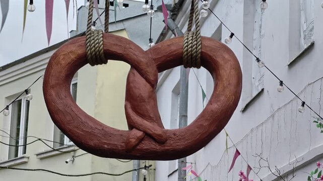A large wooden pretzel hanging from a rope, perfect for festivals or events