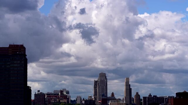 Stunning stock video of dramatic moving clouds rolling over a sprawling modern city skyline, perfect for weather, urban, and travel projects.
