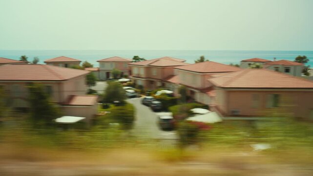 Train journey in Calabria and a view of holiday villas near the blue sea
