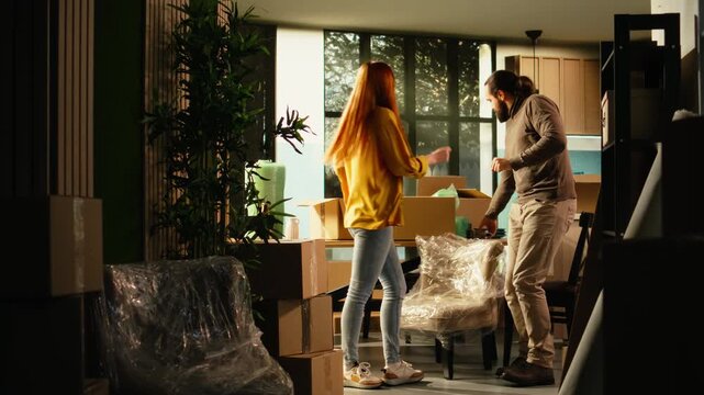 Happy couple dances and has fun together in their new house, celebrating a first home purchase, a fresh beginning and the satisfaction of home ownership.