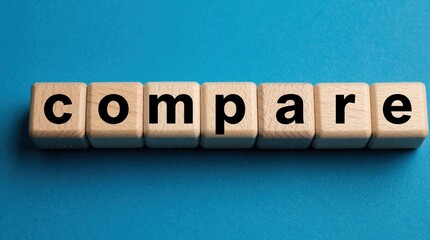 Obraz premium Wooden blocks spell out the word compare on a blue background. This represents analysis and choice making in business decisions and strategy.