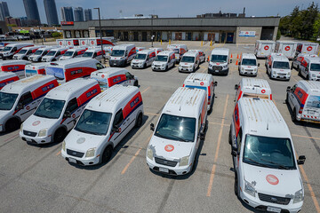 Obraz premium Canada Post delivery vans parked in a fleet parking lot. Canada. Canada Post is discontinuing door-to-door delivery and transitioning to community mailboxes: Toronto, Ontario, Canada - May 17, 2026