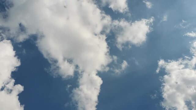 White Clouds Drifting Across Bright Blue Sky on Sunny Day