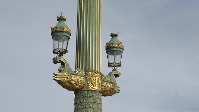 Decorative lamppost with intricate gold and green design illuminating historical Place de la Concorde