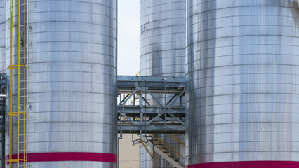Close up of industrial chemical storage tank and oil refinery silo facility architecture © Kenstocker
