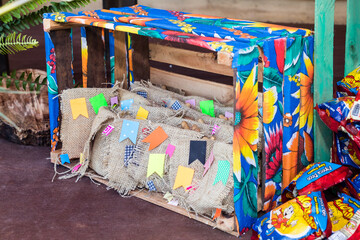 Naklejka premium Rustic Festa Junina decoration with wooden crates, burlap bags and colorful mini flags