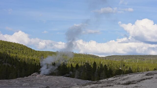 Early morning walk viewing geothermal features and hot springs in Old Faithful area of Upper Geyser Basin, summer vacation exploring Yellowstone National Park
