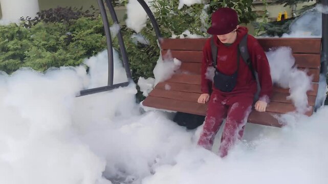 Happy 14 years old teenager in sportswear swinging through foam on garden swing outdoors