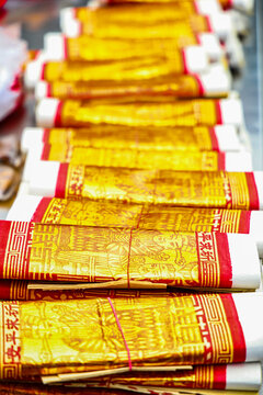  stacks of golden Joss papers arranged neatly on a table for religious ceremonies and offerings