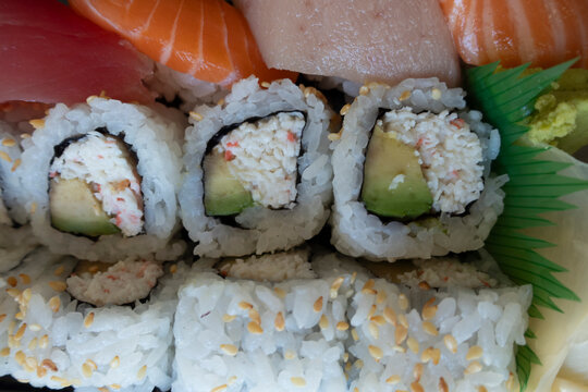 Assorted Sushi Platter with Nigiri and California Rolls. Close-up of an assorted Japanese sushi platter featuring salmon, tuna and white fish nigiri with California rolls filled with avocado and imita