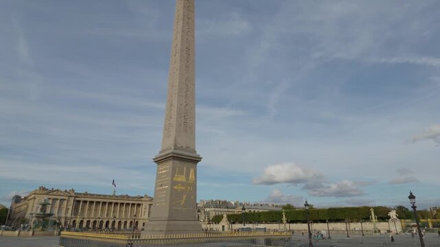 Luxor Obelisk dominating Place de la Concorde with a historic building and fountain under cloudy sky