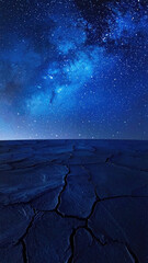 Fototapeta premium Cracked desert ground beneath starry blue night sky with glowing Milky Way over barren landscape