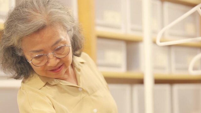 Happy Asian senior women friends shopping at department store in the city. Healthy elderly woman enjoy urban lifestyle choosing and buying gift at shopping mall. Active seniors people mental health.