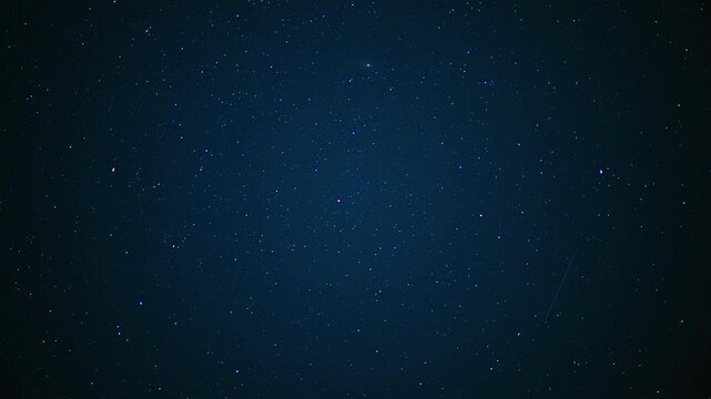 Wide view of a starry night sky with faint clouds of the Milky Way