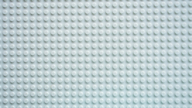 White plastic building brick baseplate texture with raised round studs pattern background